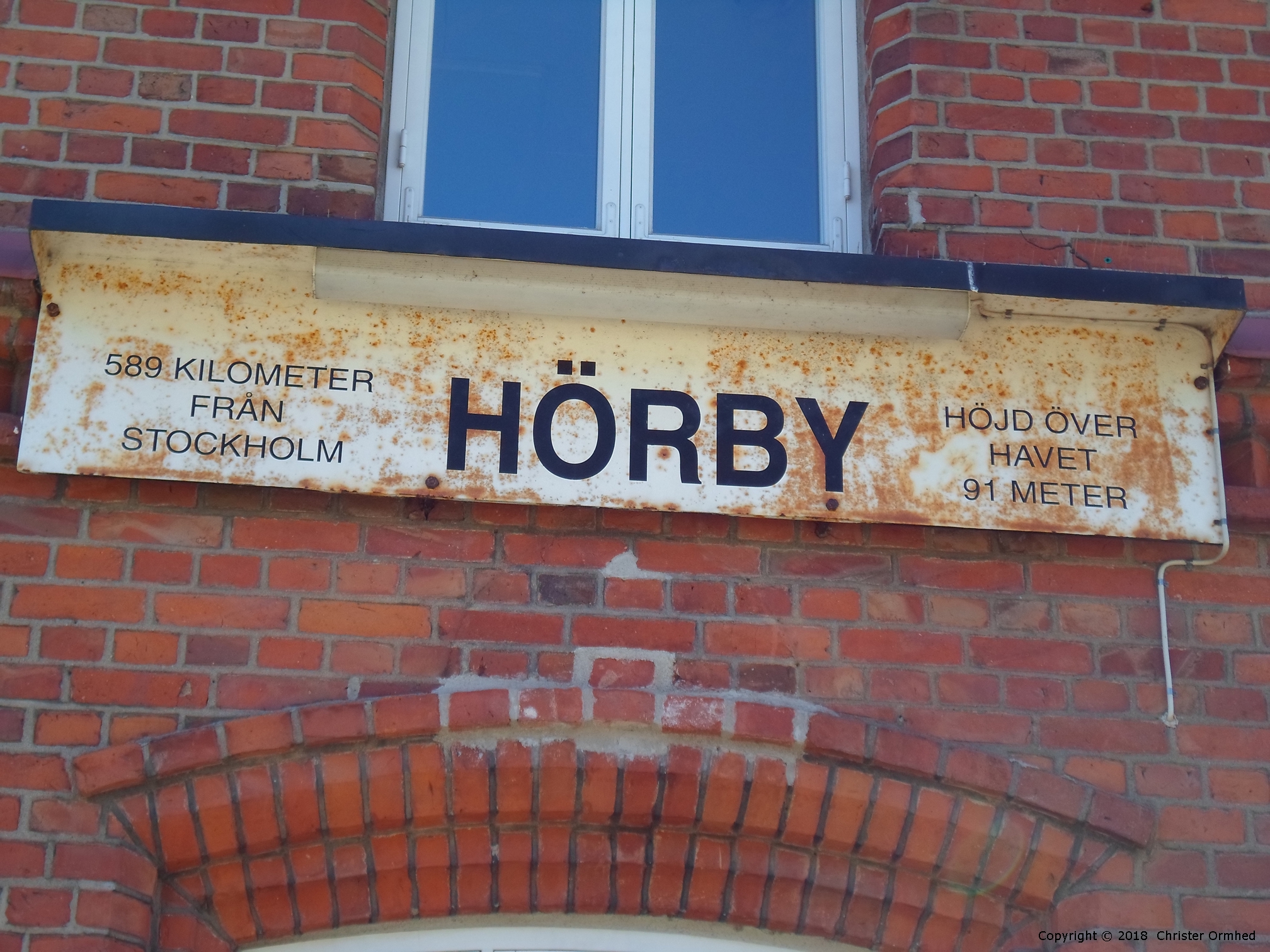 Närbild på skylten på stationshuset i Hörby.